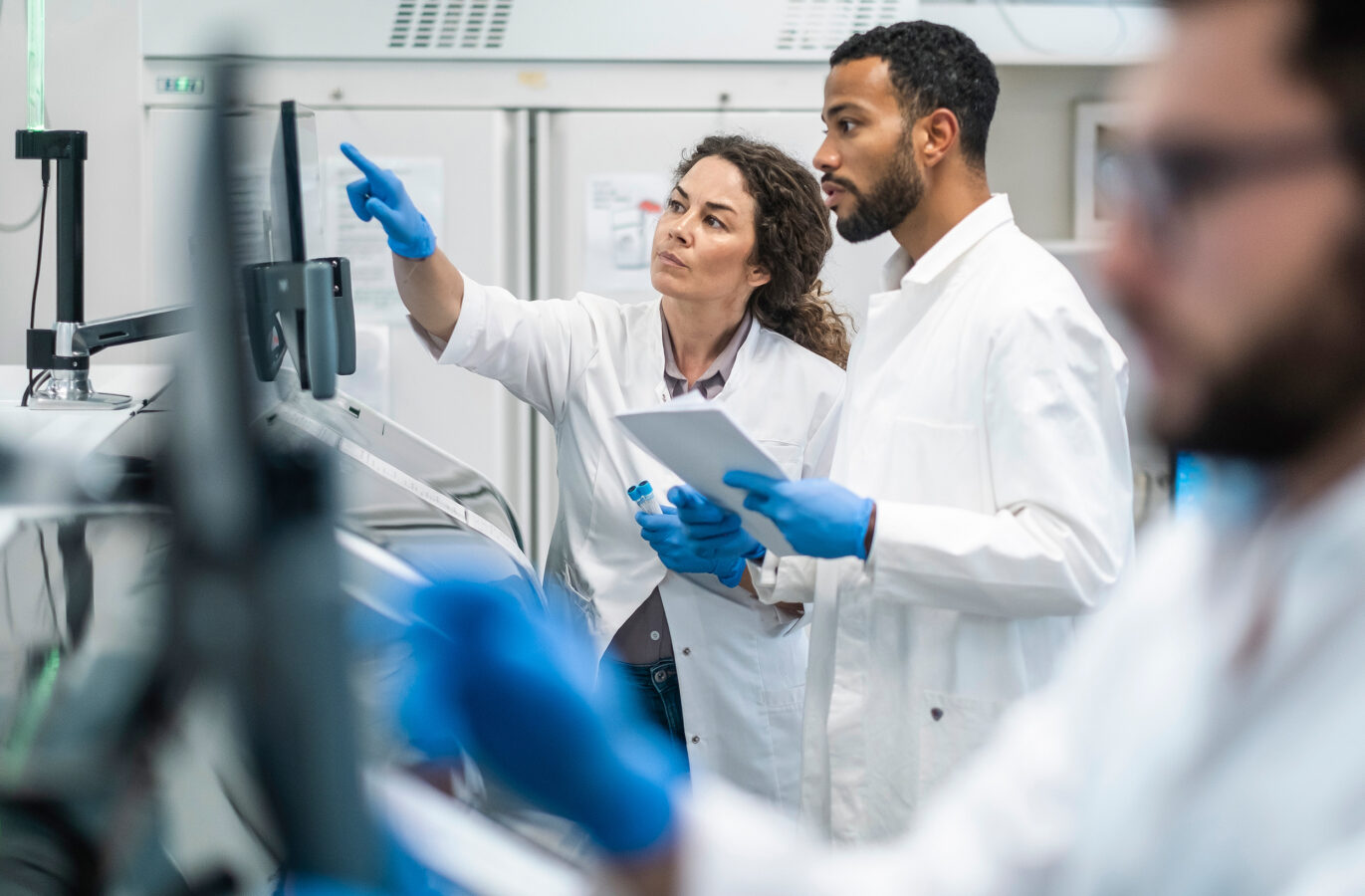 Lab researchers analyzing results on-screen | Des chercheurs en laboratoire analysant les résultats à l’écran.